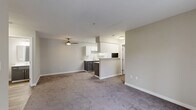 Located at Harbour Pointe Boulevard in Mukilteo, WA, this well-appointed 2-bedroom, 2-bathroom residence offers a thoughtfully designed single-floor layout. The entrance opens into a spacious, open-concept living, dining, and kitchen area bathed in neutral tones and plush carpet. A ceiling fan adds comfort to the generous living space, which flows seamlessly to a private balcony through sliding glass doors, bringing in natural light and outdoor views.

The kitchen features white upper cabinetry paired with charcoal lower cabinets, light countertops, wood-look flooring, and a full suite of appliances including a stainless refrigerator and electric range. A peninsula provides additional workspace and separation from the living area.

Both bedrooms are carpeted and well-lit with natural light from multiple windows. The primary bedroom includes a walk-in closet and its own access. A second bedroom features a sidelight window and baseboard heating. Four closets in total ensure ample storage throughout.

Both bathrooms are finished with wood-look flooring, gray vanity cabinetry, white countertops, and elegant marble-patterned tub/shower surrounds with curved curtain rods. A dedicated laundry area completes this functional and modern home.