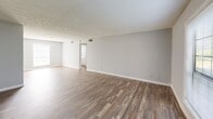 Located in Riverdale, GA, this single-story, 3-bedroom, 2-bathroom home offers a practical and comfortable layout designed for everyday living. The open living room greets you upon entry with warm wood-look flooring, neutral gray walls, and a textured ceiling that adds subtle character. Natural light filters in through the front windows, enhancing the airy feel of the space.

The kitchen flows seamlessly from the living area and features white cabinetry, granite-style countertops, a stainless steel sink, and a black range. A half-wall pass-through visually connects the kitchen to the main living space, making the layout feel open and connected.

The primary bedroom is generously sized and includes a dedicated closet, providing ample storage. The additional bedrooms are finished with plush carpeting and textured ceilings, each offering a window for natural light. A hallway connects the bedroom wing to the rest of the home.

Both bathrooms are finished in a clean, white palette with wood-look flooring. Each features a full tub-shower combination — one with classic white subway tile surround — offering a crisp, functional aesthetic throughout.

A dedicated closet and connecting hallway complete the efficient floor plan, making this home a well-rounded option in the Riverdale community.