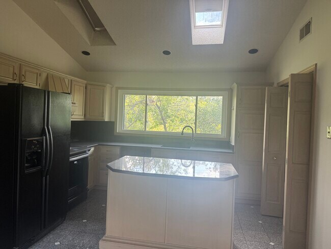 Kitchen with Granite, Island, and Skylights - 109 E Sanctuary Dr