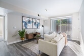 Located at 888 Davis St in San Leandro, CA, this thoughtfully designed 2-bedroom, 2-bathroom residence offers a comfortable and modern living experience across a single floor. The open-concept living and dining area is bright and welcoming, featuring light-toned walls, wood-style flooring, and sliding glass doors that flood the space with natural light and provide direct access to a private patio with outdoor views. The kitchen is well-equipped with granite countertops, white shaker-style upper cabinets, contrasting gray lower cabinets, stainless steel appliances including a gas range and refrigerator, and a peninsula with a undermount sink — ideal for both cooking and casual entertaining. The primary bedroom is a comfortable retreat, highlighted by natural light streaming through shuttered windows and convenient closet storage. Its en-suite bathroom features granite countertops, gray cabinetry, and a large vanity mirror. The second bedroom is equally well-lit and includes a built-in closet with sliding doors. The second bathroom mirrors the same clean, modern aesthetic with a shower/tub combination. Additional highlights include a utility room, four closets throughout, and consistent wood-style flooring that ties the home together with a cohesive, contemporary feel.