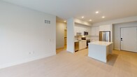 Located at 2330 Union Street in Fort Myers, Florida, this two-bedroom, three-bathroom unit offers a thoughtfully designed single-floor layout with a clean, modern aesthetic. The open-concept living and kitchen area serves as the heart of the home, featuring recessed lighting, light-toned flooring, and a kitchen outfitted with white shaker cabinetry, a center island, stone countertops, and stainless steel appliances including a refrigerator, range, microwave, and dishwasher. Both bedrooms are bright and airy, each equipped with a ceiling fan and a window offering views of lush tropical greenery. The spacious primary bedroom includes a dedicated closet and access to a generously sized en-suite bathroom featuring a dual-sink vanity with stone countertops, backlit mirrors, tile flooring, and a glass-enclosed shower. A second full bathroom includes a soaking tub and shower combination with floor-to-ceiling tile surround and chrome fixtures. A third bathroom serves as a powder room with light wood-tone tile flooring. Additional storage is provided by a walk-in closet fitted with wire shelving. The unit's neutral color palette and consistent light flooring create a cohesive, bright atmosphere throughout.