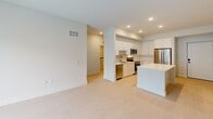 Located at 2330 Union Street in Fort Myers, Florida, this two-bedroom, three-bathroom unit offers a thoughtfully designed single-floor layout with a clean, modern aesthetic. The open-concept living and kitchen area serves as the heart of the home, featuring recessed lighting, light-toned flooring, and a kitchen outfitted with white shaker cabinetry, a center island, stone countertops, and stainless steel appliances including a refrigerator, range, microwave, and dishwasher. Both bedrooms are bright and airy, each equipped with a ceiling fan and a window offering views of lush tropical greenery. The spacious primary bedroom includes a dedicated closet and access to a generously sized en-suite bathroom featuring a dual-sink vanity with stone countertops, backlit mirrors, tile flooring, and a glass-enclosed shower. A second full bathroom includes a soaking tub and shower combination with floor-to-ceiling tile surround and chrome fixtures. A third bathroom serves as a powder room with light wood-tone tile flooring. Additional storage is provided by a walk-in closet fitted with wire shelving. The unit's neutral color palette and consistent light flooring create a cohesive, bright atmosphere throughout.