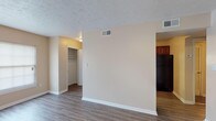Located at 200 Verdant Dr in Greenville, NC, this single-floor unit offers a well-organized layout designed for practical, comfortable living. Throughout the space, durable wood-look flooring in warm, neutral tones provides a cohesive foundation, complemented by crisp white baseboards and soft beige walls that create a clean, inviting atmosphere.

The kitchen is appointed with rich, dark cherry-toned cabinetry featuring raised-panel doors and ample storage above and below. Dark granite-style countertops line both sides of the galley-style layout, offering generous prep space alongside black appliances.

The living and sleeping areas are bright and open, benefiting from large windows fitted with blinds that allow for natural light control. One room features a ceiling fan with integrated lighting, adding both comfort and function. Multiple rooms include dedicated closet space, with at least one featuring a well-organized reach-in closet with a clothing rod, ideal for maximizing storage.

The bathroom is cleanly finished with wood-look tile flooring, a full-size soaking tub and shower combination with bright white surrounds, and classic white fixtures. A towel bar adds a functional touch to the neutral, low-maintenance design.

Textured ceilings are present throughout, and HVAC vents are well-positioned to ensure consistent climate control across all rooms. The overall ambiance is tidy and move-in ready.