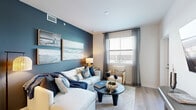 Located at 1905 Champs Dr. in Naples, FL, this thoughtfully designed three-bedroom, three-bathroom unit offers a coastal-inspired aesthetic throughout its single-floor layout. Light wood flooring flows seamlessly across the space, complementing a bright and cohesive color palette.

The open kitchen is a standout feature, showcasing white shaker cabinetry, white quartz countertops, a subway tile backsplash, and stainless steel appliances including a range, microwave, and refrigerator. A central island provides additional prep and casual dining space. The adjoining living room features a bold navy accent wall adorned with coastal artwork, creating a stylish and inviting atmosphere with natural light streaming through the windows.

The primary bedroom offers a serene retreat with a textured accent wall, ceiling fan, and natural light. Each additional bedroom is well-appointed with ceiling fans and windows, maintaining the coastal theme throughout. The bathrooms are finished with white vanities, quartz countertops, and clean tile work, including a tub-shower combination in one bath.

Closet space is available in multiple rooms, and hallways connect the layout efficiently. The overall ambiance is relaxed and refined, reflecting the coastal Naples lifestyle with modern finishes and a warm, welcoming design.