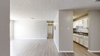 Located at 9901 Brockington Rd in Sherwood, Arkansas, this single-floor, 2-bedroom, 2-bathroom home offers a practical and well-organized layout. The living area features light-toned luxury vinyl plank flooring, neutral gray walls, a textured ceiling, and a large window that brings in natural light and street views, creating a bright and open atmosphere. A pass-through connects the living space to the galley-style kitchen, which is lined with white cabinetry, dark countertops, and black appliances including a range, refrigerator, and dishwasher, all set over matching vinyl plank flooring. A central hallway links the main living spaces to the private sleeping quarters. Both bedrooms are carpeted and feature ceiling fans with integrated lighting. The spacious primary bedroom includes a dedicated closet and direct access to one of the two bathrooms. The second bedroom offers a sliding-door closet for ample storage. Both bathrooms are consistent in design, each featuring white cabinetry, dark countertops, a single-basin sink, a full tub-shower combination with built-in shelving, and vinyl plank flooring. The overall palette throughout is clean and neutral, creating a cohesive and move-in ready environment.