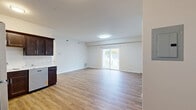 Located at 130 Slade Dr in Alden, NY, this single-floor, 2-bedroom, 1-bathroom unit offers a clean, modern layout designed for comfortable everyday living. Light-toned hardwood-style flooring runs throughout the entire space, creating a cohesive and easy-to-maintain interior.

The combined living and dining area is the heart of the unit, offering generous open space bathed in natural light. Sliding glass doors lead directly to a private balcony, providing pleasant outdoor views and seamless indoor-outdoor connectivity. The kitchen is well-equipped with rich dark-toned cabinetry, stainless steel appliances including a refrigerator, range, microwave, and dishwasher, and ample counter space — all flowing naturally from the main living area.

The spacious primary bedroom comfortably accommodates large furnishings and features a closet, while the second bedroom includes a window overlooking the exterior. With five closets distributed throughout the unit, storage is abundant. The bathroom is outfitted with a walk-in shower featuring multiple stainless steel grab bars, offering both style and accessibility. A connecting hallway ties all rooms together efficiently. The unit's neutral palette and modern finishes create a bright, move-in-ready atmosphere throughout.