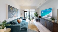 Located at 501 NW Seventh Ave in Fort Lauderdale, FL, this thoughtfully designed one-bedroom, one-bathroom residence offers a modern, open-concept floor plan across a single level. Light wood flooring flows throughout, complementing the bright, neutral palette that enhances the sense of space.

The combined kitchen, dining, and living area serves as the heart of the home. The contemporary kitchen features two-tone cabinetry — white upper cabinets paired with slate-blue lower units — accented by a subway tile backsplash, white quartz countertops, a black matte faucet, and a full suite of stainless steel appliances including a range, microwave, and dishwasher. A peninsula island with seating provides a practical dining and gathering space, while pendant lighting adds a refined touch overhead.

The living area is anchored by floor-to-ceiling sliding glass doors that open to a private balcony, allowing abundant natural light and outdoor views. The bedroom offers a comfortable, well-proportioned retreat with large windows overlooking lush surroundings. Two closets and an in-unit laundry area provide excellent storage and convenience. The bathroom and hallway complete this efficiently organized, stylish residence ideal for modern urban living.