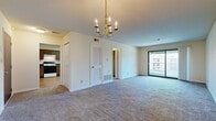Located at 10105 Wornall Rd in Kansas City, Missouri, this single-floor residence offers a well-organized layout designed for comfortable everyday living. The main living and dining area is generously proportioned, finished with wall-to-wall carpeting and illuminated by an elegant chandelier overhead. A louvered utility closet and additional storage are conveniently positioned within this central space, while large sliding glass doors open to a private balcony, filling the room with natural light and outdoor views.

The kitchen features light hardwood-style flooring, dark-toned wood cabinetry with dark countertops, a double-basin sink, and includes a full suite of appliances — an electric range and a full-size refrigerator. Ample upper and lower cabinet storage, along with a tall pantry-style cabinet, provides practical functionality.

The bedroom is a well-sized, carpeted retreat with its own set of sliding glass doors leading to an outdoor space, a reach-in closet with sliding doors, and direct access to a private en-suite bathroom. The bathroom includes a vanity with wood cabinetry and a well-lit mirror. Throughout the residence, neutral wall tones and consistent carpeting create a cohesive and move-in ready atmosphere.