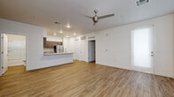 Located at 13404 N 30th Ave in Phoenix, AZ, this well-appointed single-floor residence offers three bedrooms and two bathrooms within a thoughtfully designed open-concept layout. Light wood-style flooring flows consistently throughout the home, creating a cohesive and modern aesthetic. The kitchen is a standout feature, equipped with stainless steel appliances including a refrigerator, microwave, and range, complemented by sleek wood-grain cabinetry and granite-style countertops. A kitchen peninsula with a double-basin sink bridges the kitchen and living area seamlessly. The spacious living room benefits from natural light streaming through large windows with vertical blinds, and is finished with a contemporary ceiling fan. Each of the three bedrooms continues the warm flooring theme and includes ceiling fans and window treatments, with the primary bedroom offering generous proportions. A walk-in closet with built-in shelving and hanging rods provides ample storage. The two bathrooms feature dual-sink vanities with granite-style countertops, wood-grain cabinetry, and a shower-tub combination with sliding glass doors. A dedicated in-unit laundry closet houses a stacked washer and dryer, adding everyday convenience to this clean and modern Phoenix home.