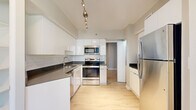 Located at 400 15th St S in Arlington, Virginia, this well-appointed 2-bedroom, 2-bathroom residence offers a clean, modern aesthetic throughout its thoughtfully designed single-floor layout. Light-toned hardwood flooring flows seamlessly through every room, creating a bright and cohesive atmosphere.

The welcoming entrance leads into a spacious living room bathed in natural light, with floor-to-ceiling sliding glass doors opening to a private balcony overlooking lush greenery and the surrounding Arlington skyline. The kitchen is a standout feature, outfitted with high-gloss white cabinetry, dark stone countertops, white subway tile backsplash, stainless steel appliances including a range, microwave, dishwasher, and refrigerator, and track lighting overhead.

The generously sized primary bedroom features a large wraparound corner window framing treetop and city views, filling the room with abundant daylight. The second bedroom also benefits from expansive corner windows with urban views. Both bedrooms include dedicated closets for ample storage. The bathrooms are finished in a contemporary style with a glass-enclosed shower, modern vanity with dark countertop, and clean tile work. The overall ambiance is bright, modern, and move-in ready.
