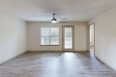 Located at 801 Hickory Level Rd in Villa Rica, Georgia, this one-bedroom, one-bathroom residence offers a thoughtfully laid-out single-floor design with a clean, neutral aesthetic throughout. The open-concept living and kitchen area serves as the heart of the home, featuring light wood-style luxury vinyl plank flooring, a textured ceiling, and a ceiling fan with integrated lighting. Natural light flows in through multiple windows fitted with blinds, and a glass door leads to an outdoor deck, enhancing the airy feel of the space. The kitchen is equipped with a peninsula island featuring a built-in sink, ample cabinetry with light gray finishes, stainless steel appliances including a refrigerator, and a skylight that brightens the work area. A hallway connects the main living space to the private areas of the residence. The spacious bedroom is carpeted for comfort, features two windows allowing for generous natural light, and is accented by a ceiling fan. The full bathroom includes a single-sink vanity with cabinetry, a toilet, and a tub-shower combination with tile surround and grab bars. A dedicated laundry room accommodates a full-size washer and dryer and includes overhead wire shelving for storage. The unit is completed by a closet with light wood-style flooring, ideal for additional storage.