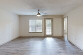 Located at 801 Hickory Level Rd in Villa Rica, Georgia, this one-bedroom, one-bathroom residence offers a thoughtfully laid-out single-floor design with a clean, neutral aesthetic throughout. The open-concept living and kitchen area serves as the heart of the home, featuring light wood-style luxury vinyl plank flooring, a textured ceiling, and a ceiling fan with integrated lighting. Natural light flows in through multiple windows fitted with blinds, and a glass door leads to an outdoor deck, enhancing the airy feel of the space. The kitchen is equipped with a peninsula island featuring a built-in sink, ample cabinetry with light gray finishes, stainless steel appliances including a refrigerator, and a skylight that brightens the work area. A hallway connects the main living space to the private areas of the residence. The spacious bedroom is carpeted for comfort, features two windows allowing for generous natural light, and is accented by a ceiling fan. The full bathroom includes a single-sink vanity with cabinetry, a toilet, and a tub-shower combination with tile surround and grab bars. A dedicated laundry room accommodates a full-size washer and dryer and includes overhead wire shelving for storage. The unit is completed by a closet with light wood-style flooring, ideal for additional storage.