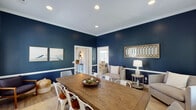 Located at 112 Stonemill Dr in Lynchburg, Virginia, this single-floor home combines classic architectural details with modern farmhouse charm. The entryway makes a strong first impression with distinctive herringbone-patterned tile flooring, warm lighting, a round wall mirror, and a marble-topped accent ledge — setting an inviting tone from the moment you step inside.

The living and sitting areas feature striking navy blue accent walls accented by crisp white crown molding and a chair-rail detail, creating a bold yet refined aesthetic. A shiplap accent wall adds a modern farmhouse touch, while light hardwood flooring runs throughout, balancing the deep color palette with warmth and continuity.

The dining area is enclosed by full shiplap wall paneling on all sides, lending a cozy, cottage-inspired feel. Large windows allow generous natural light to fill the space, with views of the surrounding greenery. A substantial wood farmhouse dining table serves as the room's centerpiece.

Connecting spaces flow openly between rooms, offering a cohesive layout that feels both functional and stylish. The consistent use of recessed lighting, white trim, and carefully coordinated finishes throughout gives the home a polished, well-appointed character. Overall, this Lynchburg residence presents a harmonious blend of bold design choices and comfortable, livable interiors.
