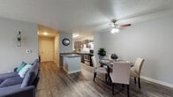 Located at 413 Spring Lake Blvd in Mishawaka, Indiana, this two-bedroom, two-bathroom unit offers a well-designed, single-floor layout that balances comfort and functionality. The open-concept living, dining, and kitchen area creates a seamless flow throughout the main living space, all unified by durable hardwood-style flooring and soft, neutral gray walls.

The kitchen is a standout feature, equipped with dark espresso cabinetry, granite countertops, stainless steel appliances including an electric range and dishwasher, and an under-cabinet range hood. A peninsula with additional counter space connects the kitchen to the dining area, which comfortably accommodates a round dining table. In-unit laundry is also conveniently located within the kitchen corridor.

The living room is bright and inviting, featuring a ceiling fan and large sliding glass doors that flood the space with natural light and provide access to an outdoor area. Both bedrooms are carpeted and sized to comfortably accommodate full furnishings, with ample closet storage. The bathrooms are cleanly finished with hardwood-style flooring and neutral tones. Throughout the unit, the design maintains a cohesive, modern aesthetic that is both practical and welcoming.