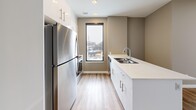 Located at 1425 Block Line Rd in Kitchener, Ontario, this well-appointed 2-bedroom, 1-bathroom unit offers a thoughtfully designed layout with modern finishes throughout. Light-toned luxury vinyl plank flooring flows seamlessly through the main living areas, complemented by warm taupe-grey walls and crisp white trim and doors.

The welcoming entrance hallway features ample closet space, leading into a bright, open-concept combined dining and living area. Large sliding glass doors connect the living space to a private balcony with open views of the surrounding Kitchener neighbourhood. The contemporary kitchen is efficiently laid out with white cabinetry, stainless steel appliances, a clean-line countertop with an undermount sink, and a tall window that brings in natural light.

Both bedrooms are generously proportioned, each featuring large windows with city views, light-filled interiors, and dedicated closet storage — including a sliding double-door closet in the primary bedroom. The full bathroom is finished with large-format floor tiles, a soaker tub with vertical subway tile surround, and a white vanity with integrated sink. A dedicated in-unit laundry room with stacked washer and dryer adds everyday convenience, rounding out this functional and stylish urban residence.