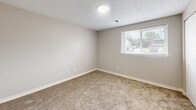 Located at 2714 South Emporia Street in Wichita, Kansas, this single-floor, one-bedroom, one-bathroom unit offers a practical and efficiently designed layout. The kitchen is a standout feature, equipped with warm wood-toned cabinetry, a white refrigerator, an electric range with overhead ventilation, and a double-basin sink set into a continuous countertop that doubles as a breakfast bar-style divider — providing a natural separation between the kitchen and the main living area. A dedicated laundry hookup nook is conveniently positioned within the kitchen space. The bedroom is carpeted and comfortably sized, featuring neutral walls, a textured ceiling, a closet with a full-panel door, and a window that allows natural light and outside views. The bathroom is straightforward and clean, offering a full-size tub and shower combo with white surround walls, chrome fixtures, and an overhead cabinet for storage. Throughout the unit, neutral tones and light-colored walls create a consistent, understated aesthetic. The open doll-house view reveals a well-organized floor plan that maximizes usability across the entire space, making this unit a practical option in the Wichita area.