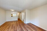 Located at 1106 Prospect in Santa Rosa, CA, this two-story home offers 2 bedrooms and 3 bathrooms spread evenly across two floors. The main level features an open-concept living and dining area finished with warm hardwood-style flooring and a textured ceiling. A sliding glass door in the living room fills the space with natural light and provides direct access to a private outdoor patio. The galley-style kitchen is well-appointed with white shaker cabinetry, quartz countertops, stainless steel appliances including a gas range, dishwasher, and refrigerator, plus a deep single-basin sink. A carpeted staircase connects the two levels, with a conveniently located bathroom on the main floor. Upstairs, both bedrooms feature plush carpet, built-in closets with sliding doors, and windows that bring in natural light with views of surrounding greenery. The primary bedroom includes its own closet and access to a dedicated bathroom. Each bathroom is finished with white vanities, chrome fixtures, and hardwood-style flooring. Utility rooms and hallways provide practical storage and circulation throughout. The home's neutral palette and clean finishes create a bright, functional living environment.