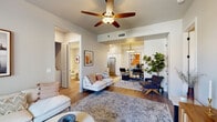 This single-floor residence offers a thoughtfully designed layout that balances open living with private retreats. The main living area is an inviting, open-concept space anchored by warm hardwood-style flooring, a ceiling fan overhead, and a neutral color palette that creates a bright and airy ambiance. The living room flows seamlessly into the dining area, which is illuminated by a stylish chandelier and complemented by a lush indoor plant, adding a natural touch to the contemporary setting. A sliding glass door in the living area provides access to the outdoors and fills the space with natural light.

The kitchen is well-equipped with crisp white shaker cabinetry, quartz countertops, stainless steel appliances including a refrigerator, range, microwave, and dishwasher, and a window above the sink that brings in additional natural light. The layout is efficient and practical, ideal for everyday cooking.

The bedroom features plush carpeting, multiple windows with blinds, and a ceiling-mounted light fixture, creating a calm and restful environment. A spacious walk-in closet with wrap-around shelving and hanging rods provides generous storage. A dedicated home office offers ample workspace beneath a modern chandelier. The full bathroom includes a tub-shower combination, white vanity, and hardwood-style flooring, completing this functional and stylish residence.