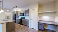 Located at 13555 Cullen Blvd in Houston, TX, this single-story, 2-bedroom, 2-bathroom residence offers a thoughtfully designed layout with modern finishes throughout. The kitchen serves as a central highlight, featuring dark-toned cabinetry, granite countertops, a subway tile backsplash, black appliances including a gas range and refrigerator, and a peninsula island with an integrated sink and stylish pendant lighting overhead. Track lighting adds a contemporary touch, and open shelving provides additional storage and display space. Hardwood-style flooring flows throughout the main living areas, adding warmth and continuity. Both bedrooms are generously proportioned, bathed in natural light through multiple windows fitted with blinds, and equipped with ceiling fans. The primary bedroom includes access to a dedicated closet and a private bathroom with dark cabinetry, granite countertops, and tile flooring. The second bathroom features a soaking tub with a tiled surround and matching granite vanity finishes. Each bedroom benefits from its own closet. A dedicated laundry room with a full-size washer and dryer adds everyday convenience. The overall aesthetic is clean, neutral, and move-in ready.