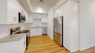 Located in Anaheim, California, this single-story 2-bedroom, 2-bathroom home offers a thoughtfully designed layout with modern finishes throughout. The kitchen is a standout feature, showcasing crisp white shaker cabinetry, grey quartz countertops, a classic subway tile backsplash, and a full suite of stainless steel appliances including a range, over-the-range microwave, dishwasher, and a large refrigerator. Warm-toned hardwood-style flooring runs through the main living and kitchen areas, adding continuity and brightness to the space. Both bedrooms are carpeted in neutral tones, offering a comfortable and quiet retreat. The rooms are bright with natural light filtering through slatted blinds and feature clean white walls that complement the overall modern aesthetic. Each bedroom includes access to a dedicated closet. The two bathrooms are well-appointed with modern chrome fixtures, white cabinetry, and quartz countertops. One bathroom features a glass-enclosed walk-in shower, while the other offers a full shower-tub combination with a window for natural light. A connecting hallway ties the layout together efficiently, making the home feel organized and functional throughout.