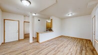 Located at 4355 Fuchsia Dr in Bellingham, Washington, this well-designed one-bedroom, one-bathroom residence offers a practical and comfortable single-floor layout. The open-concept living, dining, and kitchen area forms the heart of the home, filled with natural light from multiple windows. Light-toned, wood-look laminate flooring runs throughout the main living spaces, lending warmth and continuity to the interior.

The kitchen is efficiently laid out with ample honey-toned cabinetry, light stone-finish countertops, a peninsula with a sink that overlooks the living area, and a full suite of appliances including a stainless electric range, refrigerator, and built-in microwave. A dedicated dining and living space adjoins the kitchen, brightened by tall vertical windows that bring in views of the surrounding neighborhood.

The bedroom features plush carpeting, a sliding-door closet with a hanging rod, and direct access to the full bathroom. The bathroom is outfitted with a full soaking tub and shower combo featuring white tile surround, tile flooring, and a toilet. An in-unit laundry area adds everyday convenience. Throughout, clean white walls, warm wood trim, and consistent finishes create a cohesive and move-in-ready environment.