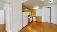 Located on Sherman Way in Winnetka, CA, this single-floor, one-bedroom, one-bathroom unit offers a thoughtfully designed and efficient layout. Warm hardwood-style flooring runs throughout the entire space, creating a cohesive and inviting atmosphere.

The kitchen is well-appointed with light maple cabinetry extending to the ceiling for ample storage, granite-style countertops, and white appliances including a refrigerator, electric range with overhead ventilation, and dishwasher. A stainless steel sink completes the functional workspace.

The bedroom is a comfortable, well-proportioned room bathed in natural light from a large window with vertical blinds. Its clean white walls and hardwood-style flooring provide a bright, neutral canvas.

The bathroom is notably designed with accessibility in mind, featuring stainless steel grab bars near the toilet and in the open, tiled shower area. A fold-down wooden shower bench, a wall-mounted sink, and hardwood-style flooring carry through the space's consistent aesthetic.

Throughout the unit, crisp white walls and flush ceiling light fixtures contribute to a clean, modern ambiance. The floorplan, as seen in the dollhouse view, presents a logical flow between rooms, making efficient use of every square foot.
