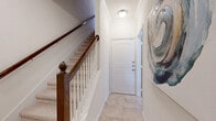 This well-appointed two-story home offers four bedrooms and five bathrooms across a thoughtfully designed layout. The entry foyer welcomes you with tile flooring, crown molding, and a classic staircase featuring a rich dark wood banister, setting an elegant tone throughout. The main living area boasts hardwood floors and large windows that flood the space with natural light, creating a warm and inviting atmosphere. The combined dining room and kitchen is a standout feature, with the kitchen showcasing dark espresso cabinetry, granite countertops, stainless steel appliances, a large center island with bar seating, and track lighting overhead. The dining area complements this with hardwood floors and generous natural light from multiple windows. The spacious primary bedroom features hardwood floors, multiple windows with outdoor views, crown molding, and a ceiling fan. Its en-suite bathroom is well-equipped with a double granite vanity, soaking tub, separate shower, and tile flooring. Additional bedrooms are carpeted and bright, each with access to well-finished bathrooms featuring granite countertops and tile flooring. Crown molding is a consistent architectural detail throughout, lending a refined character to every room in this generously scaled home.