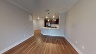 Located along Teel Parkway in Frisco, Texas, this single-story residence offers a well-designed open-concept layout that seamlessly connects the living area and kitchen. Rich hardwood-style flooring extends throughout the main living spaces, complemented by crisp crown molding and neutral gray walls that create a clean, modern aesthetic.

The kitchen is a standout feature, showcasing dark espresso cabinetry that extends to the ceiling for ample storage, a classic white subway tile backsplash, and light-toned countertops. A full suite of stainless steel appliances includes a French door refrigerator with ice and water dispenser, electric range, over-the-range microwave, and a double-basin undermount sink. Pendant lighting over the kitchen peninsula adds both functionality and style, while the peninsula itself provides seating and open sightlines into the living area.

The bedrooms offer plush neutral carpeting and are bathed in natural light through large windows fitted with blinds. Ceiling fans provide additional comfort. The bathroom continues the design language of the home with dark espresso cabinetry, a single-sink vanity with light countertops, a framed mirror, and hardwood-style flooring. Access to a walk-in closet with built-in shelving is conveniently located off the bathroom.