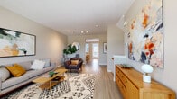 Located at 1850 S Quebec Way in Denver, Colorado, this multi-level home spans three floors and delivers a clean, modern aesthetic throughout. Light wood-tone flooring flows through the main level, complementing the neutral warm-beige palette that unifies each space. The open living area is generously proportioned, featuring track lighting overhead and a seamless connection to the dining room, which benefits from natural light streaming through slatted blinds. A half bath on the main level features updated white cabinetry and light tile flooring for added convenience. The kitchen stands out with crisp white shaker cabinetry, quartz countertops, a subway tile backsplash, stainless steel appliances, and ample storage — a highly functional and attractive space for cooking and entertaining. Carpeted stairs lead between floors, where the primary bedroom offers plush carpet, natural window light, and direct access to a spacious walk-in closet outfitted with wire shelving. The overall ambiance is calm and contemporary, with each room thoughtfully designed to balance comfort and practicality. The multi-floor layout provides well-defined living zones, making this Denver home a versatile and inviting residence.