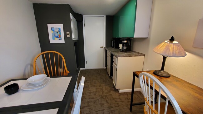 View towards kitchenette, which contains a small fridge, microwave, coffee maker, and crockpot. - 1348 6th St S