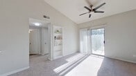 This single-story, 1-bedroom, 1-bathroom unit offers a thoughtfully designed layout that maximizes functionality and comfort. The combined kitchen and living area serves as the heart of the home, featuring plush carpeted flooring, vaulted ceilings, a ceiling fan with light fixture, and a sliding glass door that opens to a private balcony — filling the space with abundant natural light and outdoor views. Built-in shelving adds a decorative and practical touch to the living area.

The kitchen is efficiently designed with white cabinetry, black appliances including a refrigerator, range, and microwave, and a peninsula counter with a marble-style surface and built-in sink — ideal for casual dining or meal prep. A skylight above the kitchen enhances the brightness of the cooking area.

The generously sized bedroom features carpet flooring, a ceiling fan, and a large window that invites natural light throughout the day. It connects to a sizable walk-in closet outfitted with multiple hanging rods and shelving for ample storage.

The bathroom features wood-look tile flooring, a vanity with white cabinetry, and a bathtub with a decorative shower curtain. Clean, neutral tones throughout the unit create a bright and cohesive ambiance.