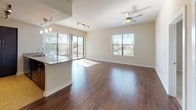 This single-story, 2-bedroom, 2-bathroom residence offers a thoughtfully designed layout that balances open communal spaces with private retreats. The main living area is anchored by rich, dark hardwood flooring that extends throughout, complemented by neutral-toned walls and ceiling fans that enhance air circulation. Multiple windows, including a sliding glass door, flood the space with natural light while providing views of the surrounding landscape. A granite-topped kitchen peninsula separates the living area from the kitchen, which is outfitted with dark espresso cabinetry, granite countertops, stainless steel appliances, and a decorative tile backsplash in cool grey tones—adding a modern contrast to the warm wood elements.

Both bedrooms offer a quieter atmosphere, featuring plush carpeting and ample room for furnishings. The two bathrooms are finished with large-format tile flooring, dark vanity cabinetry topped with granite, and well-lit mirrors. The primary bathroom includes an extended layout that connects to a walk-in closet, providing generous storage. Throughout the unit, consistent finishes and a cohesive color palette create a polished, move-in-ready environment.