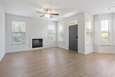 Located in Birmingham, AL, this well-appointed single-story home offers a thoughtfully designed open-concept layout that seamlessly connects the kitchen, dining, and living areas. The kitchen is outfitted with dark wood cabinetry, a subway tile backsplash, white quartz countertops, a peninsula with an undermount sink, stainless steel dishwasher, and pendant lighting — all overlooking the main living space. The dining nook features a bay window configuration that floods the area with natural light, while the living room includes a fireplace and ceiling fan. Light wood-tone flooring flows throughout the main living areas, adding warmth and continuity. The spacious primary bedroom features a bay window, plush carpeting, and a walk-in closet with wire shelving for organized storage. The second bedroom also offers carpet flooring, a ceiling fan, and a bright window. Both bathrooms are finished with wood-toned vanities, white countertops, and tub/shower combinations with tiled surrounds. A dedicated laundry room houses a full-size washer with overhead shelving. The attached single-car garage provides direct interior access and additional storage potential. Four closets throughout the home ensure ample storage for everyday living.
