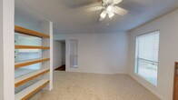 Located at 2400 44th St, this two-floor residence offers a clean, neutral aesthetic throughout its interior spaces. The home features wall-to-wall carpet flooring in a warm, light beige tone that carries consistently across multiple rooms, contributing to a cohesive and comfortable feel underfoot. Textured ceilings add a traditional architectural detail found throughout the space.

Natural light plays a prominent role in the ambiance of the home. Windows fitted with horizontal and vertical blinds allow for adjustable light control while maintaining privacy. A sliding glass door in one of the main rooms opens to an outdoor area, further enhancing the connection between interior and exterior spaces.

A ceiling fan with an integrated light fixture is installed in one of the carpeted rooms, providing both ventilation and overhead lighting. The interior walls are painted in a clean white and light gray palette, giving the rooms a bright and airy character. Panel-style doors with standard hardware are present throughout, maintaining a consistent design language across the home.

The layout spans two floors, offering functional separation between living areas. Overall, the space presents a straightforward, well-maintained interior suited for comfortable everyday living.