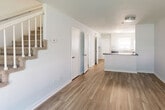 This two-story, 3-bedroom, 2-bathroom home on Blair Street in Thomasville, NC offers a clean, modern aesthetic with a thoughtful layout spread evenly across two floors. The main level features an open-concept living and kitchen area with warm luxury vinyl plank flooring that flows throughout. The kitchen is equipped with white cabinetry, light stone countertops, and black appliances including a refrigerator, electric range, and dishwasher, complemented by a window above the sink that brings in natural light. The living room is bright and open, with a large front-facing window offering views of the outdoors and convenient access to the front entry. A staircase connects the two levels. Upstairs, the three bedrooms are finished with plush carpet and ceiling fans, providing a comfortable retreat. The spacious primary bedroom features dual reach-in closets, offering generous storage. Both bathrooms are finished with white vanities, marble-style countertops, and LVP flooring, maintaining a consistent, clean design language. The home's neutral color palette of soft whites and light grays throughout creates a bright, airy ambiance well-suited for modern living.