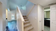 This two-story residence in Clearwater, Florida offers a well-designed layout across two floors, featuring 2 bedrooms, 4 bathrooms, and a thoughtful mix of functional and inviting spaces. The main floor serves as the heart of the home, anchored by a bright living room with soaring vaulted ceilings, a ceiling fan, light wood-tone flooring, and a sleek fireplace with a dark tile surround. Large windows and a glass-paneled door flood the space with natural light and provide views of the surrounding greenery. The kitchen is efficiently designed with white cabinetry, dark granite-style countertops, light hardwood flooring, and stainless steel appliances including a range, microwave, and refrigerator. A window above the sink adds natural brightness to the cooking space. Upstairs, the bedrooms offer a cozy retreat with plush carpeting, ceiling fans, and windows overlooking lush outdoor scenery. Each bedroom is complemented by a walk-in closet outfitted with wire shelving systems for organized storage. The bathrooms feature wood-look flooring, vanities with dark countertops, and clean tile work. A hallway with light wood-look flooring connects the upper-level spaces seamlessly, completing this well-appointed Clearwater home.