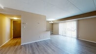 Located at 5292 Clubhouse Dr in North Olmsted, Ohio, this single-floor unit offers a practical and well-maintained layout with a cohesive neutral color palette throughout. The open living and dining area is finished with light-toned laminate wood flooring and features a chandelier overhead, a pass-through counter connecting to the kitchen, and a large sliding glass door fitted with vertical blinds that allows natural light to fill the space.

The kitchen is equipped with dark espresso cabinetry, granite-style countertops, a stainless steel sink, and a peninsula that provides additional prep and seating space. A chandelier above the adjacent dining area adds a finished touch to the combined kitchen and dining zone.

The bedrooms are carpeted and feature generous closet space, with bifold closet doors providing easy access to built-in hanging rods. Windows with horizontal blinds allow for natural light and outdoor views. An additional room with laminate flooring offers flexible use as an office or utility space.

The bathroom is notably updated, showcasing dark cabinetry with a granite-style countertop, a wide vanity mirror, recessed lighting, wood-look flooring, and a tiled tub and shower surround. Clean white trim throughout the unit ties all areas together for a consistent, polished appearance.