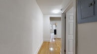 Located at 33 Coleman Street in Bridgeport, Connecticut, this two-bedroom, one-bathroom unit offers a functional and efficient single-floor layout. Polished hardwood floors run throughout the main living areas and bedrooms, lending warmth and a classic character to the space. A central hallway connects the rooms, providing a logical flow from entry to living quarters.

The galley-style kitchen features warm wood cabinetry, granite-style countertops, tile backsplash, and black appliances including a gas range with overhead microwave. A window and glass-panel door bring in natural light, making the kitchen feel open despite its compact design.

Both bedrooms are bright and well-proportioned, each outfitted with large windows that invite natural light and offer views of the surrounding neighborhood. Classic cast-iron radiators provide reliable heat, and window AC units ensure comfort year-round. The primary bedroom is generously sized, offering ample room for furnishings.

The bathroom is cleanly finished with white subway-style tile surrounding a full tub-shower combination, white grid floor tile, a toilet, and a vanity with granite countertop. A window provides natural ventilation. The overall aesthetic throughout the unit is clean, neutral, and move-in ready, suited for those seeking straightforward, comfortable city living in Bridgeport.