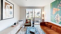 Located at 3705 S Alaska St in Seattle's vibrant Columbia City neighborhood, this 1-bedroom, 1-bathroom unit offers a thoughtfully designed open-concept layout. Light-toned hardwood flooring flows throughout, unifying the kitchen, dining, and living areas into a cohesive, welcoming space.

The kitchen is outfitted with slate-gray flat-front cabinetry, open shelving, a white subway tile backsplash, light countertops, and a full suite of stainless steel appliances including a French door refrigerator, dishwasher, and microwave. A butcher-block dining table with bar seating sits adjacent, creating a practical and stylish eat-in area.

The living room benefits from a large sliding glass door that invites natural light and provides outdoor views of the surrounding neighborhood. The bedroom is a comfortable retreat, featuring clean white walls and warm wood flooring, with a dedicated closet for storage.

The bathroom is finished with white vertical subway tile in the tub surround, a gray floating vanity, light countertop, and wood-look flooring, maintaining the modern aesthetic found throughout. Recessed lighting and clean lines complete the polished, contemporary character of this well-designed Seattle residence.