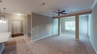 Located at 6038 Hixson Pike in Hixson, Tennessee, this single-story unit offers a well-organized, open-concept floor plan designed for comfortable everyday living. The living and dining areas flow seamlessly together, finished with plush neutral-toned carpeting, crown molding, and a ceiling fan. A chandelier anchors the dining area, which connects directly to the kitchen via a granite-topped breakfast bar overhang.

The kitchen is outfitted with gray shaker-style cabinetry, granite countertops, stainless steel appliances including a range, microwave, and refrigerator, and wood-look flooring. Pendant and recessed lighting add both style and function. An adjacent dedicated laundry closet houses a full-size GE washer and dryer.

The bedrooms are carpeted and painted in warm taupe tones. The primary bedroom includes access to a private bathroom and a separate closet. A secondary bedroom benefits from a large window with exterior views and ample natural light.

Bathrooms feature granite-topped vanities with gray cabinetry, wood-look flooring, and tub/shower combinations with brushed nickel fixtures. The consistent use of neutral finishes, quality materials, and thoughtful layout make this a well-appointed single-floor residence.