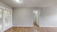 This 800-square-foot, two-bedroom, two-bathroom apartment at Addison Apartments At The Park offers a practical and well-organized single-floor layout. Consistent light wood-look flooring flows throughout the unit, complemented by neutral gray walls, white trim, and textured ceilings that create a clean, cohesive aesthetic.

The combined kitchen and living room area anchors the unit. The kitchen features white cabinetry, granite-style countertops, a double basin sink, and black appliances, with a window providing natural light. The open living area is spacious and benefits from natural light through a large window with views of greenery.

Both bedrooms are generously sized, with the primary bedroom measuring 170 square feet. Each bedroom includes a ceiling fan with light fixture, wood-look flooring, and access to a dedicated closet. The primary bedroom features a glass-paned door, while the second bedroom includes a standard window. The unit offers a total of three closets, providing ample storage throughout.

Each of the two bathrooms includes a full tub-shower combination with white subway tile surrounds. The unit's neutral palette and consistent finishes across all rooms contribute to a bright, move-in-ready atmosphere suited for comfortable everyday living.