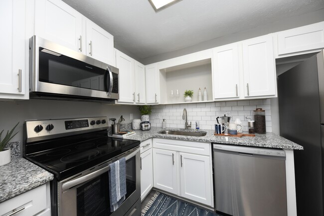 Kitchen with granite counters, modern cabinetry, and stainless appliances - The Edwin