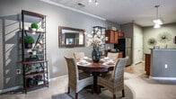 Located at 1805 Kerwyck Pl in Chesapeake, Virginia, this single-floor residence offers a thoughtfully designed layout with a warm, cohesive aesthetic throughout. The kitchen is well-equipped with rich medium-toned wood cabinetry, dark granite countertops, stainless steel appliances including a range, microwave, and dishwasher, and light hardwood-style flooring that adds brightness to the space. Pendant lighting and a stainless steel sink with a modern faucet complete the functional design.

The open living area features plush carpeting, crown molding, and a seamless flow into the dining space, creating an inviting and connected common area. Natural light filters in through windows dressed with blinds and drape panels throughout the home.

The bedrooms are carpeted and feature neutral taupe walls, windows with natural light, and ample closet space. Each room offers a comfortable and restful atmosphere with thoughtful layout and storage solutions.

Two full bathrooms serve the residence, each featuring tile flooring in a stone-like finish, a shower/tub combination, and wood-toned vanity cabinetry. One bathroom includes a pedestal sink, adding a classic touch. Overall, the home presents a consistent, warm palette and practical design across all spaces.