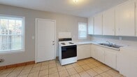 Located at 322 Clarence St in Charlotte, NC, this two-floor residential property offers a straightforward and functional layout throughout. The home features warm hardwood flooring that runs through the main living areas and bedrooms, lending a cohesive and inviting feel across multiple rooms.

The kitchen is outfitted with white cabinetry, laminate countertops, a tile floor, and an electric range, providing ample storage and workspace. A dedicated utility area adjacent to the kitchen includes additional cabinetry, a sink, and space for a full-size refrigerator, making everyday household tasks convenient.

The bedrooms are generously proportioned, each featuring the same warm hardwood floors and neutral gray walls. Windows fitted with blinds allow natural light to filter in, and wall-mounted air conditioning units and baseboard heaters ensure year-round comfort. Several bedrooms also include closets, adding to their practicality.

The full bathroom is cleanly appointed with white tile surrounding a tub-shower combination, hardwood flooring, and a window that brings in natural light while maintaining privacy.

Throughout the home, the neutral color palette, clean lines, and consistent flooring create a cohesive atmosphere that is easy to personalize. The property's two-floor layout provides a clear separation of living spaces, making it a practical and comfortable residence in the Charlotte area.