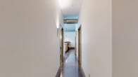 This single-floor unit showcases a cohesive industrial-contemporary design, anchored by gleaming polished concrete floors that flow throughout the living spaces. The open layout is defined by crisp white walls and clean architectural lines, creating a bright and versatile interior.

The living areas feature multiple sets of green-framed French doors and large grid-pane windows that flood the rooms with natural light while offering views of the surrounding urban streetscape. Access to an exterior balcony further extends the living space outdoors.

The kitchen is outfitted with light natural wood cabinetry, dark granite countertops with a peninsula bar, stainless steel appliances including a refrigerator and microwave, and a classic tile backsplash. Exposed cylindrical ductwork and pendant lighting add industrial character overhead.

Two bathrooms serve the unit, each featuring granite vanity tops and light wood cabinetry. One bathroom includes a full tub-shower combination with decorative tile surround, while the other offers a more open layout with vessel-style sinks. A dedicated laundry area accommodates a stacked Whirlpool washer and dryer. Bedrooms include louvered-door closets and generous natural light.