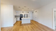 Located at 301 Ben Allen Rd in Nashville, TN, this modern single-story residence offers 2 bedrooms and 2 bathrooms with a clean, contemporary design throughout. The open-concept kitchen and living area serves as the heart of the home, anchored by a sizeable center island with quartz countertops and stylish pendant lighting overhead. The kitchen is outfitted with stainless steel appliances — including a refrigerator, range, microwave, and dishwasher — white cabinetry, open shelving, and a tile backsplash, all complemented by light wood-look flooring that flows seamlessly into the living area. French doors in the living room open directly to a private patio, filling the space with natural light. The primary bedroom is generously sized, featuring a ceiling fan, a window with outdoor views, and access to a well-appointed en suite bathroom with a dual-sink vanity, quartz countertops, and tile flooring. The second bedroom also benefits from natural light through a dual-pane window. Three closets provide ample storage throughout. A hallway connects the living spaces to the private quarters, completing this well-designed Nashville residence.