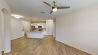 Located at 16333 Columns Way in Baton Rouge, Louisiana, this well-appointed single-story home offers three bedrooms and two bathrooms within a thoughtfully designed open-concept floor plan. The combined kitchen and living area serves as the heart of the home, featuring warm wood-look flooring, neutral tones, and a ceiling fan that enhances the airy feel of the space. Large windows and a door leading to an outdoor area allow natural light to fill the living room.

The kitchen is a standout feature, showcasing a central island with granite countertops, an undermount sink, and pendant lighting overhead. White cabinetry, a tile backsplash, and a full suite of stainless steel appliances—including a refrigerator, range, microwave, and dishwasher—complete the space. Track lighting adds functional brightness to the cooking area.

The bedrooms are carpeted for comfort, offering a quiet retreat from the main living areas. The bathrooms are finished with granite vanity tops, white cabinetry, wood-look flooring, and tiled tub-shower combinations. A dedicated laundry room with a full-size washer and dryer adds everyday convenience. Arched architectural details and consistent neutral finishes throughout lend the home a cohesive, welcoming character.