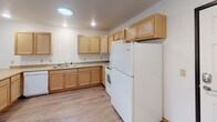 This single-floor unit at 735 Lund St N in North Hudson, Wisconsin, offers a practical and well-organized layout with consistent design choices throughout. Light hardwood-style flooring runs continuously across all rooms, complemented by white walls and warm wood trim, creating a clean and cohesive aesthetic.

The kitchen is efficiently designed in an L-shaped configuration, featuring light oak cabinetry with ample upper and lower storage, neutral laminate countertops, a double-basin sink, and white Whirlpool appliances including a refrigerator, electric range with built-in microwave, and dishwasher. Recessed lighting illuminates the space effectively.

The living areas include ceiling fans with integrated lighting and windows that allow natural light to filter in, contributing to a bright and airy atmosphere. The rooms offer a versatile, open feel suitable for various furniture arrangements.

The bathroom is designed with accessibility in mind, equipped with grab bars near the toilet, a wood-toned vanity, and consistent hardwood-style flooring. A dedicated laundry room accommodates a full-sized front-loading Whirlpool washer and dryer set, with overhead shelving for added storage convenience. Overall, the unit presents a functional, well-maintained living environment.