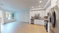 Located at 4353 Park Blvd in San Diego's desirable 92103 neighborhood, this well-designed one-bedroom, one-bathroom unit offers a clean, modern aesthetic throughout its efficiently laid-out single floor. Light wood flooring flows seamlessly across all rooms, contributing to a bright and cohesive atmosphere.

The open-concept kitchen and living area serves as the heart of the unit. The kitchen is outfitted with full stainless steel appliances — including a refrigerator, range, over-the-range microwave, and dishwasher — complemented by crisp white cabinetry, dark countertops, and a distinctive textured geometric tile backsplash. Recessed lighting illuminates the space, while a large window allows natural light to fill the living area, which offers views of palm trees and the surrounding neighborhood.

The bedroom is a comfortable and quiet retreat with its own window providing additional natural light and outdoor views. An adjacent walk-in closet features built-in shelving and dual hanging rods, offering generous storage capacity.

The bathroom is finished with marble-style tile surrounding the full soaking tub and shower, a dark-countered vanity with an undermount sink, open wall shelving, and warm wood-tone flooring. A hallway connects the rooms, providing a practical and well-organized flow throughout the unit.