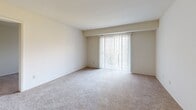 This single-floor residence at 2040 Flintshire Rd in Rosedale, Maryland, offers a practical and well-organized layout encompassing two bedrooms, two bathrooms, and a den. The living area is carpeted and bathed in natural light courtesy of a large sliding glass door fitted with vertical blinds, which opens to a private balcony with outdoor views of surrounding greenery. The open flow between the living and dining areas is enhanced by neutral wall tones and consistent carpeting throughout, creating a cohesive and welcoming atmosphere.

The kitchen is efficiently designed with warm wood cabinetry, granite-toned countertops, and a full suite of white appliances including a gas range, dishwasher, and refrigerator. A window above the sink provides additional natural light, and the marble-style tile flooring adds a clean, polished finish.

The bedrooms are generously proportioned, each featuring plush carpeting, natural light from windows with vertical blinds, and ample wall space. One bedroom includes a private en-suite bathroom with a tiled walk-in shower and wood-toned vanity. The second full bathroom is similarly appointed. The additional den provides flexible space for a home office or extra living area.